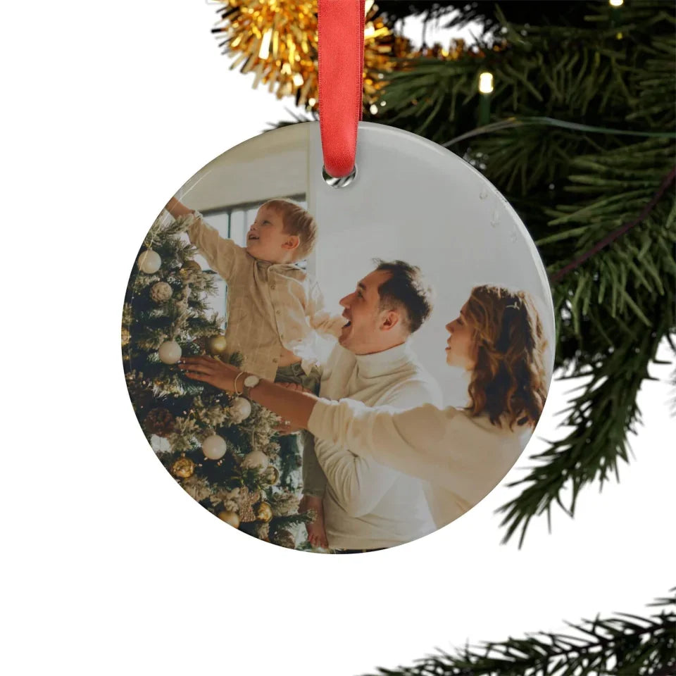 Round Christmas ornament with a family photo on a tree branch