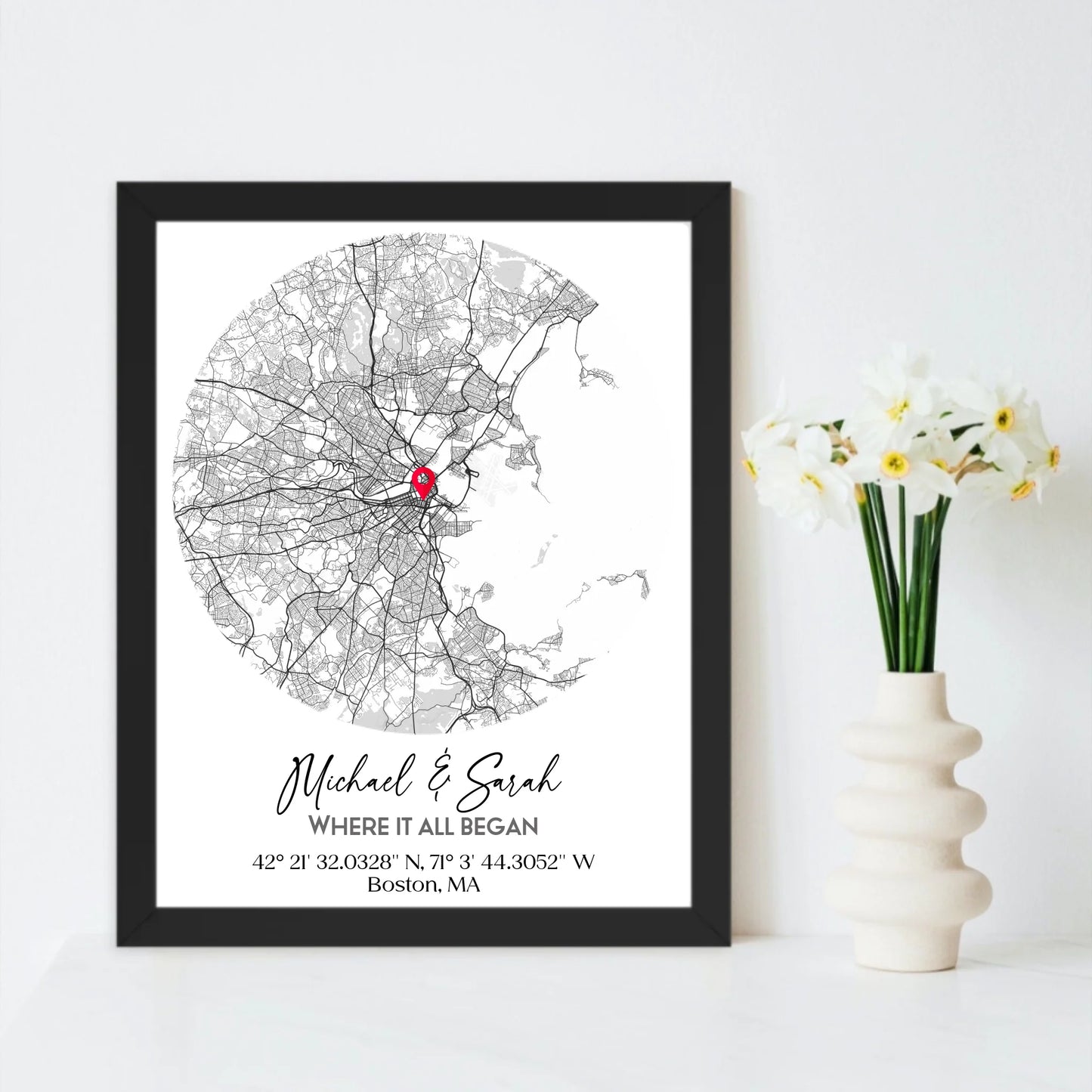 Where We Met Map Gift with an 11x14 inch black frame, showing a city map with a red pin marking a location, personalized with the names 'Michael & Sarah' and coordinates for Boston, MA.