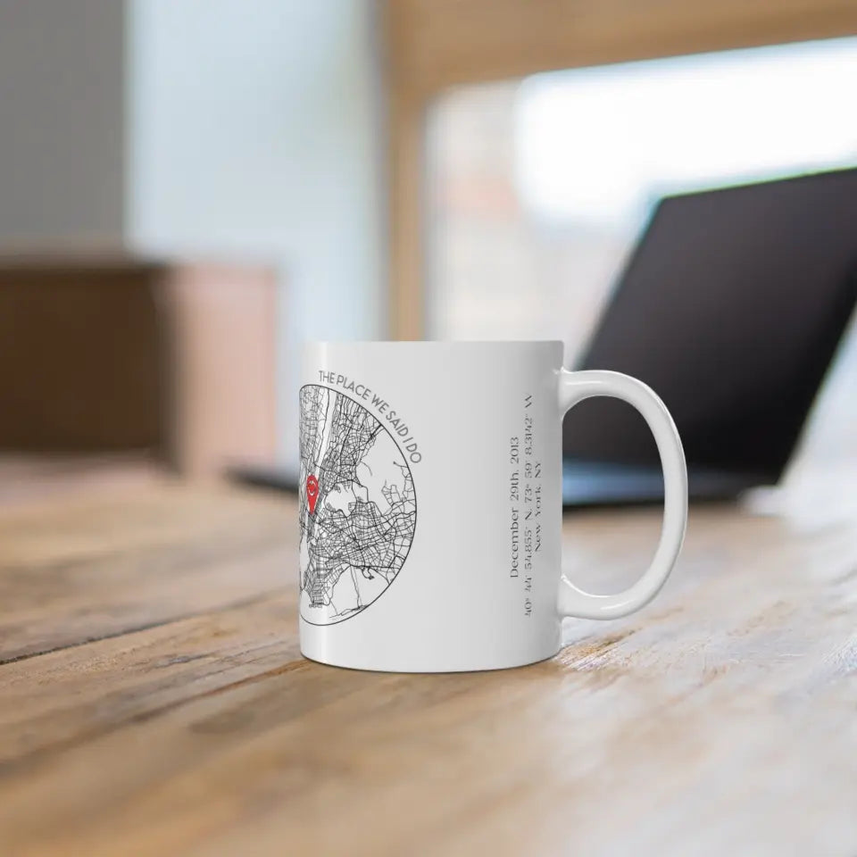 Right side of 11oz anniversary mug featuring a city map design with a red location pin, personalized with title, coordinates, date, and place.